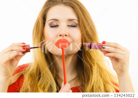 Woman applying lipstick or lip gloss 134243022