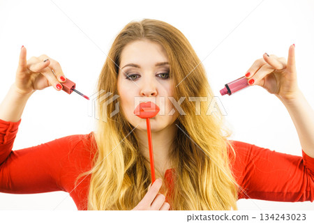 Woman applying lipstick or lip gloss 134243023