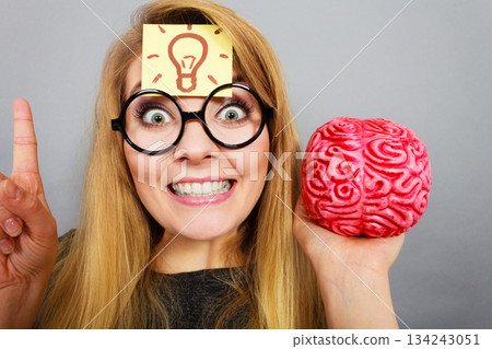 Weird woman holding brain having idea 134243051