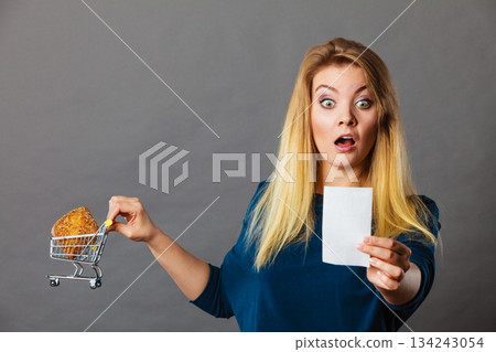 Shocked woman holding shopping basket with bread 134243054