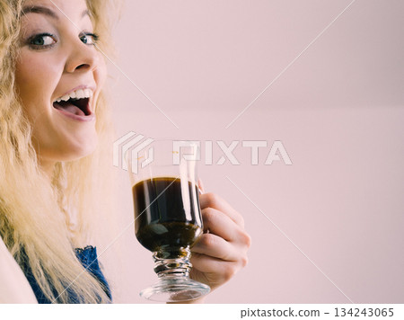 Positive woman drinking her morning coffee Positive woman drinking her morning coffee 134243065