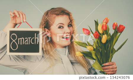 Woman holds tulips, board with text 8 march Woman holds tulips, board with text 8 march 134243076