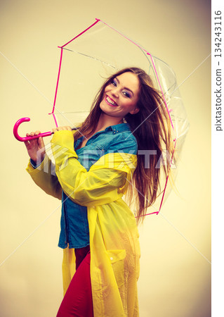 Woman wearing waterproof coat under umbrella 134243116