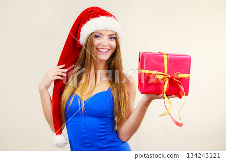 Woman in santa claus hat holds gift box. Christmas time 134243121