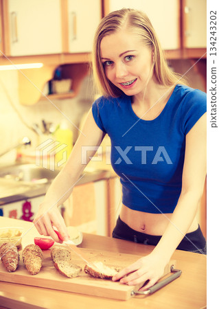 Woman preparing healthy breakfast making sandwich Woman preparing healthy breakfast making sandwich 134243202