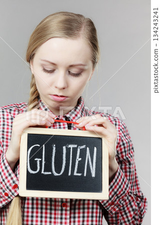 Angry woman holding board with gluten sign Angry woman holding board with gluten sign 134243241