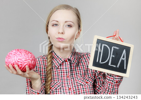 Woman holding idea sign and brain 134243243
