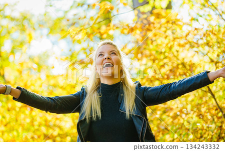 Girl throwing leaves up in air in autumn park Girl throwing leaves up in air in autumn park 134243332