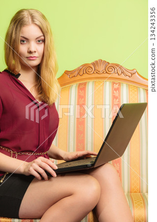 Fashion woman sitting on sofa using pc laptop 134243356
