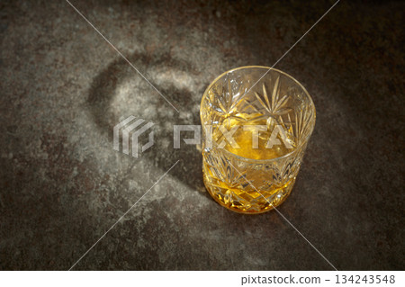 Crystal glass of whiskey on a old stone table. 134243548