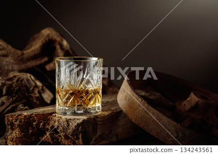 Whiskey in crystal glass on a old wooden board. 134243561