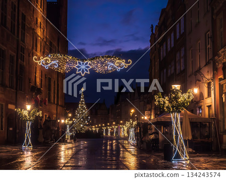 Enchanting Night Street With Christmas Lights, Decorated Trees, And Cozy Outdoor Cafes In Old Town, Gdansk, Poland 134243574