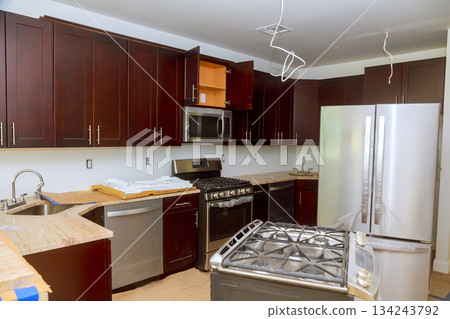 Modern kitchen wood cabinets stainless steel appliances undergoing renovation in residential area 134243792