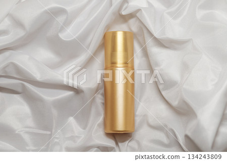 Mock up golden spray bottle for cosmetics on elegant white satin backdrop Mock up golden spray bottle for cosmetics on elegant white satin backdrop 134243809