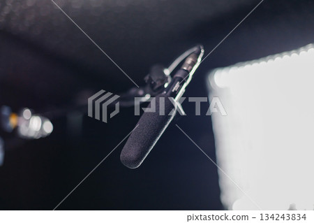 Professional microphone with a foam windscreen mounted on a boom arm, in the recording studio Professional microphone with a foam windscreen mounted on a boom arm, in the recording studio 134243834