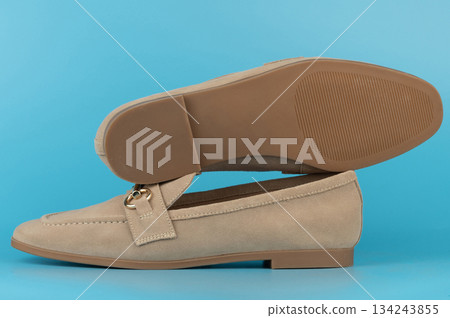 Shoe displayed on a blue background showing its design and sole Shoe displayed on a blue background showing its design and sole 134243855