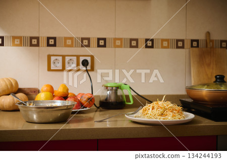 Cozy Kitchen Scene With Hash Browns, Fresh Produce And Cooking Utensils On Counter Cozy Kitchen Scene With Hash Browns, Fresh Produce And Cooking Utensils On Counter 134244193
