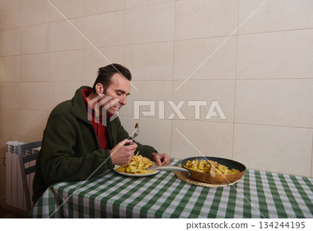 Man Eating Fries at Home Kitchen With Checkered Tablecloth, Simple Cozy Dinner Scene 134244195