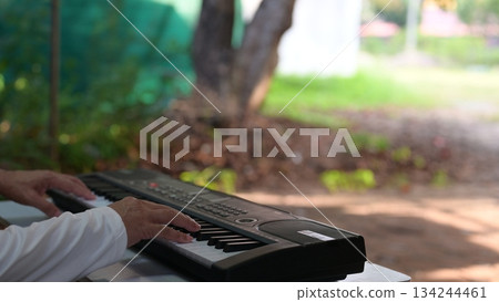Black Keyboard Harmony Hand Plays Amidst Green Foliage Tree, White Shirt In Relaxation 134244461