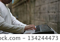 Modern Musicians Hands On Electronic Keyboard Closeup In White Shirt Against Concrete Wall Background 134244473
