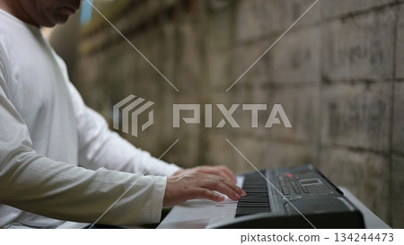 Modern Musicians Hands On Electronic Keyboard Closeup In White Shirt Against Concrete Wall Background 134244473