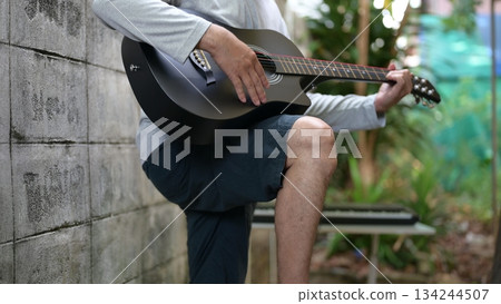 Acoustic Guitar Serenade Outdoor Musicians Hand Mastering Six String Body, Against Weathered Wall Effect Acoustic Guitar Serenade Outdoor Musicians Hand Mastering Six String Body, Against Weathered Wall Effect 134244507