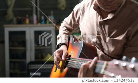 Acoustic Guitar Serenade Brown Shirt, Hand, Natural Light, And Sound hole In Indoor Setting Acoustic Guitar Serenade Brown Shirt, Hand, Natural Light, And Sound hole In Indoor Setting 134244532
