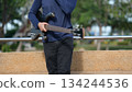 Bass Guitarist Against Light Brown Wall Outdoor Night Ambition, Building Future Trust, Dark Body Background 134244536