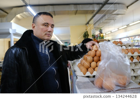 Man holding egg box in supermarket. egg box buy carton man hold checking consumer concept. 134244628