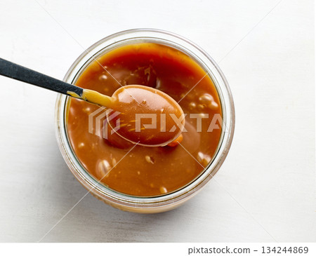 freshly cooked homemade caramel sauce in jar 134244869