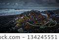 A mountain of fishing nets and marine plastic waste washed up on a stormy beach 134245551