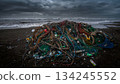 A mountain of fishing nets and marine plastic waste washed up on a stormy beach 134245552