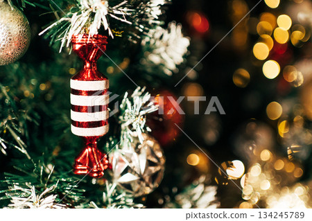 Red candy ornament hanging on christmas tree 134245789