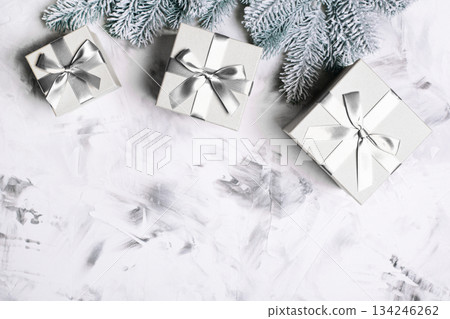 Gray gift boxes and frosted fir branches for winter holidays. Color of 2026 year dancer in the white cloud Gray gift boxes and frosted fir branches for winter holidays. Color of 2026 year dancer in the white cloud 134246262