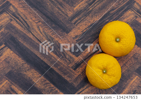 Two yuzu placed on a wood grain background. Image of winter solstice and Japanese-style material. 134247653