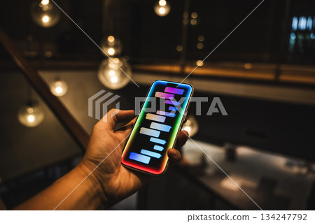 A smartphone and message screen glowing in your hand 134247792
