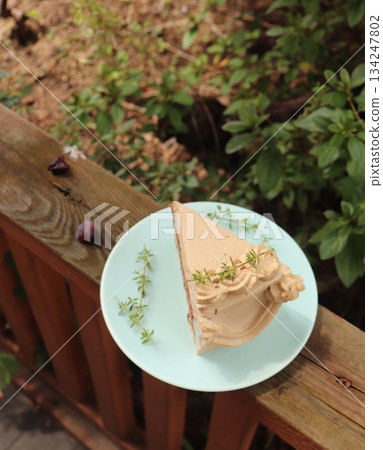 A delectable slice of cake with rich layers of cream and frosting, topped with fresh fruit or sprinkles. Perfect for dessert photography, showcasing indulgence and sweetness in food-related projects. 134247802