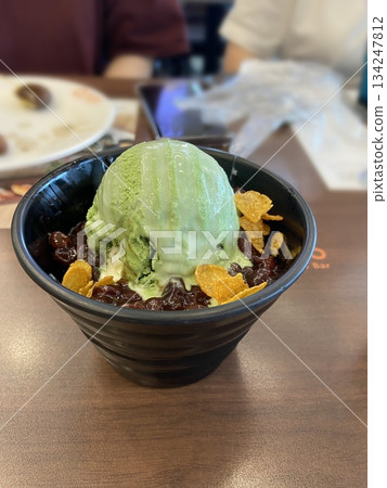 Refreshing matcha bingsu with fluffy shaved ice, rich green tea flavor, sweet red beans, and chewy rice cakes. A perfect balance of earthy, creamy, and sweet flavors for a delightful dessert! 134247812