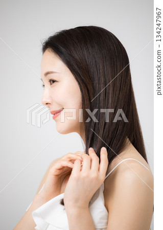美女肖像，一位擁有美麗秀髮的女子正在照料她長長的直髮。 134247967