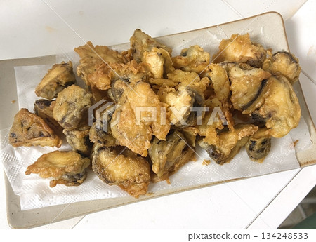 Crispy fried eggplant, golden brown and crunchy, served as a tasty snack or side dish. Perfect for food photography, showcasing the delicious texture and flavor of this popular Indonesian treat. 134248533