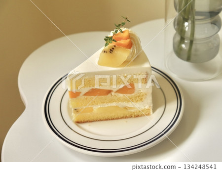 A delectable slice of cake with rich layers of cream and frosting, topped with fresh fruit or sprinkles. Perfect for dessert photography, showcasing indulgence and sweetness in food-related projects. 134248541