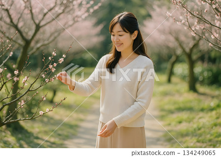 春日里，一位女子在梅園中梳妝打扮，景色自然清新。 134249065