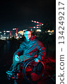 Man with disability in wheelchair in red blue rgb color light on late night walk alone in urban city 134249217