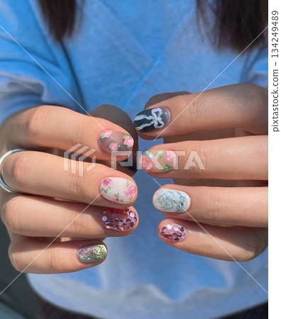 Beautiful nail art with intricate designs and vibrant colors, showcasing glossy finish, smooth texture, and detailed patterns in close-up view 134249489