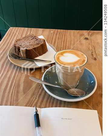 Refreshing ice americano and soft strawberry roll cake with creamy filling served on a cozy café table, offering a perfect mix of bold coffee and sweet indulgence in every peaceful bite and sip. 134249508