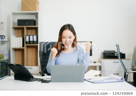 Business woman using tablet and laptop for doing math finance on an office desk, tax, 134249869