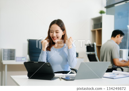 Business woman using tablet and laptop for doing math finance on an office desk, tax, 134249872