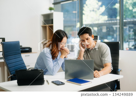A stressed business team in shock after financial failure. Upset colleagues brainstorm solutions, reacting to bad news A stressed business team in shock after financial failure. Upset colleagues brainstorm solutions, reacting to bad news 134249889