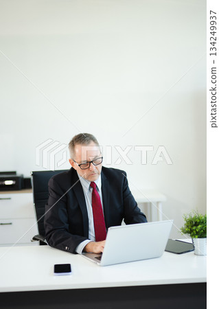 Professional businessman working at office with laptop, tablet, and notes. Perfect for business, finance, accounting, 134249937
