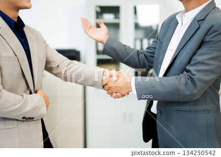 Professional handshake between two businessmen sealing a successful agreement in a modern office 134250542
